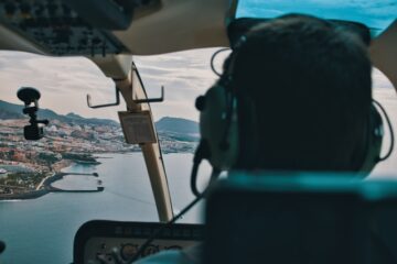 a-man-flying-a-helicopter-over-a-large-body-of-water